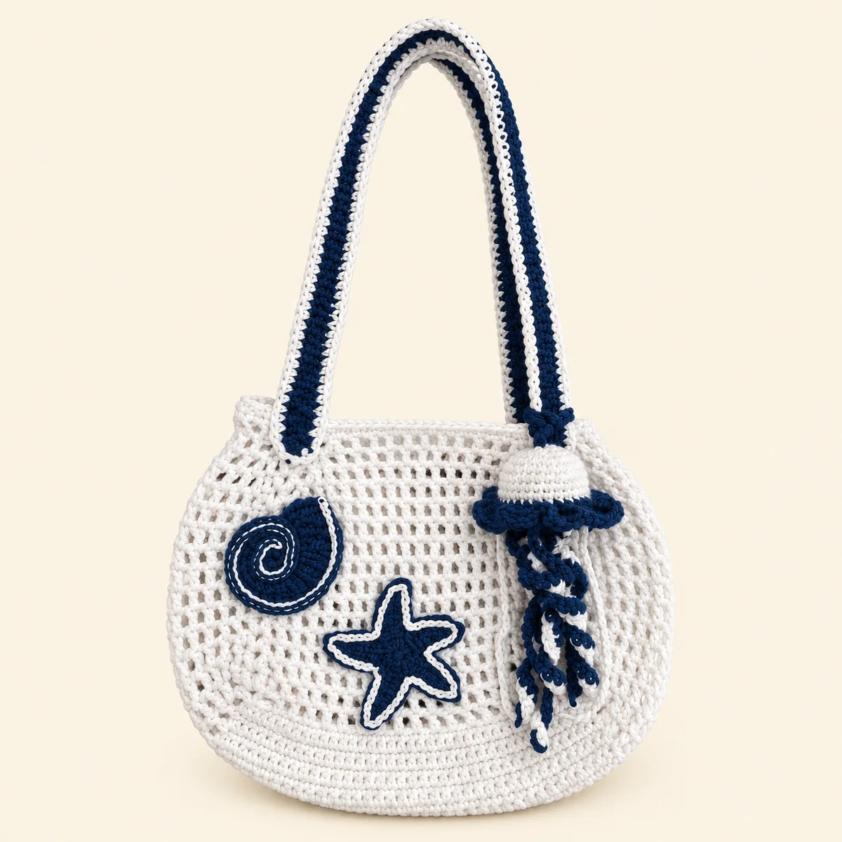 Handmade white crochet mesh shoulder bag with navy starfish and shell details and a jellyfish charm